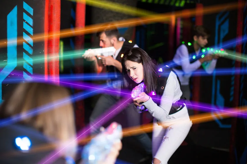 girl in colored beams during laser tag game